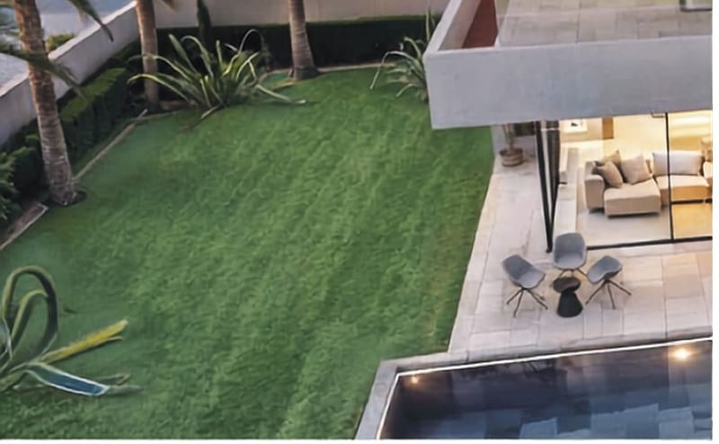Photographie communiquée : jardin paysager, terrasse et piscine vus de haut.